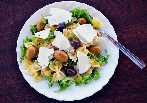 Pasta butterflies (farfalle) with mozzarella, olives and salad, Italian dish Pasta butterflies (farfalle) with mozzarella, olives and salad, Italian dish